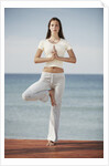 Woman doing yoga by the ocean by Anonymous