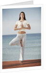 Woman doing yoga by the ocean by Anonymous