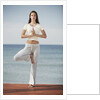 Woman doing yoga by the ocean by Anonymous