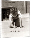 1950s Boy Ready To Shoot Kneeling On School Yard Ground Playing Game Of Marbles by Anonymous