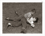 1950s Two Boys Wear Tee Shirts Blue Jeans Playing Rough Fighting Wrestling On The Grass by Anonymous