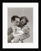 1940s Father Cradling Baby Daughter Feeding Her Bottle With Mother Looking Over His Shoulder by Anonymous
