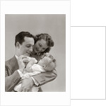 1940s Father Cradling Baby Daughter Feeding Her Bottle With Mother Looking Over His Shoulder by Anonymous
