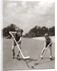 1930s 1940s 2 Boys With Sticks And Puck Wearing Roller Skates Playing Street Hockey by Anonymous