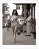1970s Man Ogling Sexy Young Woman Walking Down City Street Wearing Only A Bikini by Anonymous