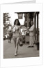 1970s Man Ogling Sexy Young Woman Walking Down City Street Wearing Only A Bikini by Anonymous