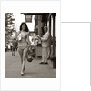 1970s Man Ogling Sexy Young Woman Walking Down City Street Wearing Only A Bikini by Anonymous