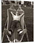 1950s Relaxed Boy Lying In Suburban Backyard Hammock by Anonymous