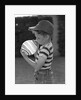 1950s Side View Of Boy In Baseball Cap and Striped T-Shirt Blowing Up Swirled Balloon by Anonymous