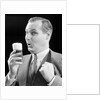 1930s Man Holding Full Foamy Glass Of Beer Making A Funny Face With His Thumb Hooked Confidently Under His Vest by Anonymous