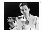 1930s Man Pouring Beer From Bottle Into Glass Look Of Anticipation Wearing Suit Tie Sweater by Anonymous