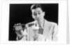 1930s Man Pouring Beer From Bottle Into Glass Look Of Anticipation Wearing Suit Tie Sweater by Anonymous