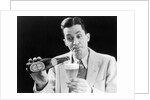 1930s Man Pouring Beer From Bottle Into Glass Look Of Anticipation Wearing Suit Tie Sweater by Anonymous