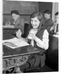 1920s School Girl Eating Lunch At Her Desk Drinking From A Bottle Of Milk Holding A Sandwich by Anonymous