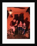 1960s 1970s Grandfather Telling Scary Story To Boys By Tent At Night Campsite In Shadows by Anonymous