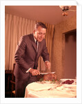 1960s Well-Dressed Man Carving Roast Beef At Dinner Table by Anonymous