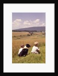 1960s Back Of Two Boys With Black And White Dog Sitting Hillside Field Looking Down To Farm by Anonymous