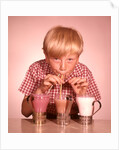 1950s 1960s Boy Drinking Three Milkshakes Through A Straw At Same Time by Anonymous