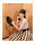 1950s Teenage Girl Talking On Telephone And Holding LP Record by Anonymous