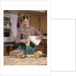 1960s Woman Housewife Mother Wearing Apron In Kitchen Pouring Milk Into Thermos For School Lunch by Anonymous