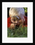 1980s Boy Using Magnifying Glass by Anonymous