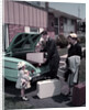 1950s Family Mother Father Daughter In Front Of Suburban House Packing Luggage In Car For Vacation by Anonymous