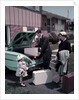 1950s Family Mother Father Daughter In Front Of Suburban House Packing Luggage In Car For Vacation by Anonymous