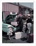 1950s Family Mother Father Daughter In Front Of Suburban House Packing Luggage In Car For Vacation by Anonymous