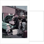 1950s Family Mother Father Daughter In Front Of Suburban House Packing Luggage In Car For Vacation by Anonymous