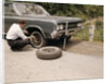 1960s Man Changing Flat Tire On Car At Side Of Rural Road Car Jack Tools Tire Iron by Anonymous