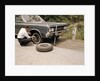 1960s Man Changing Flat Tire On Car At Side Of Rural Road Car Jack Tools Tire Iron by Anonymous