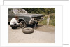 1960s Man Changing Flat Tire On Car At Side Of Rural Road Car Jack Tools Tire Iron by Anonymous