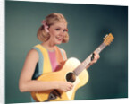 1960s Perky Young Teenager Folk Singer Playing Guitar by Anonymous