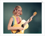 1960s Perky Young Teenager Folk Singer Playing Guitar by Anonymous