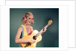 1960s Perky Young Teenager Folk Singer Playing Guitar by Anonymous