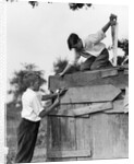 1930s Pair Of Boys Building Shack One Nailing Board To Side One On Roof With Saw by Anonymous