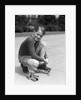 1930s Boy Fastening Metal Roller Skates by Anonymous
