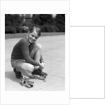 1930s Boy Fastening Metal Roller Skates by Anonymous