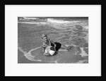 1960s Woman In Bathing Suit Lying In The Surf Holding A Beach Ball Outdoor by Anonymous