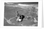 1960s Woman In Bathing Suit Lying In The Surf Holding A Beach Ball Outdoor by Anonymous
