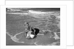 1960s Woman In Bathing Suit Lying In The Surf Holding A Beach Ball Outdoor by Anonymous
