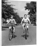 1930s 1940s Two Boys Riding Bikes On Tree Lined Street by Anonymous