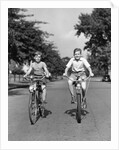1930s 1940s Two Boys Riding Bikes On Tree Lined Street by Anonymous