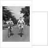 1930s 1940s Two Boys Riding Bikes On Tree Lined Street by Anonymous