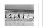 1930s Group 7 People Holding Hands Running Out Of Surf Onto Beach by Anonymous