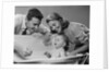 1950s Parents Leaning Over Tub Bathing Happy Baby by Anonymous