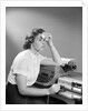1950s Ailing Secretary Sitting At Desk With Typewriter And Dictation Machine Holding Handkerchief To Forehead by Anonymous