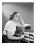 1950s Ailing Secretary Sitting At Desk With Typewriter And Dictation Machine Holding Handkerchief To Forehead by Anonymous