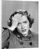 1950s Stressed Woman In Striped Dress Hold Forehead With Hand by Anonymous