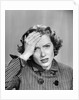 1950s Stressed Woman In Striped Dress Hold Forehead With Hand by Anonymous
